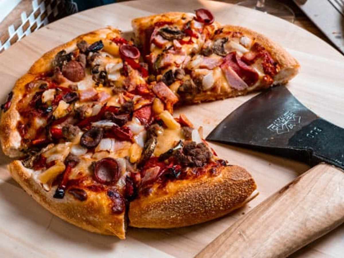 a slice of pizza sitting on top of a wooden cutting board